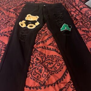 Black jeans with a bear and a letter A in green